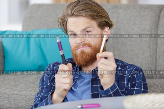 man holding cigarette and electronic vaping machine. Стоковое фото, агентство Ingram Publishing / Фотобанк Лори
