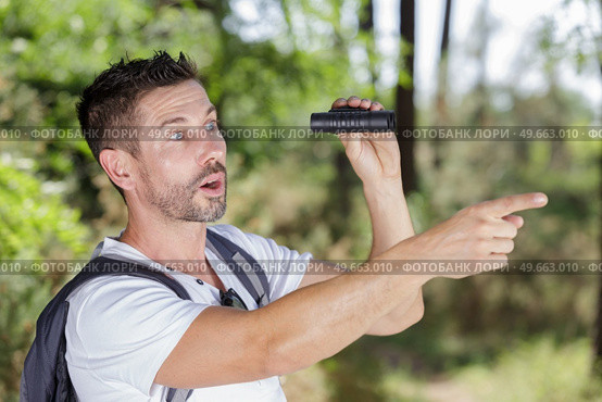 man in countryside with binoculars looking shocked and pointing. Стоковое фото, агентство Ingram Publishing / Фотобанк Лори
