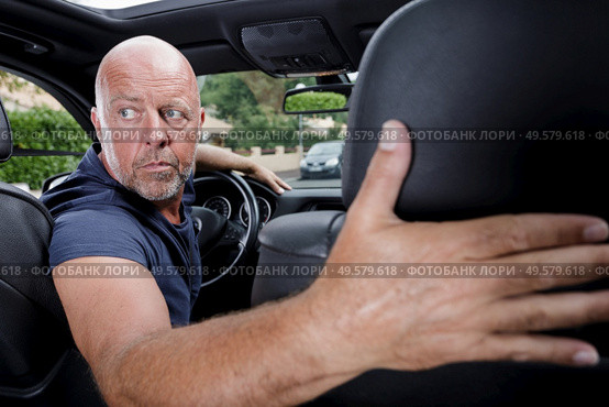 man in the car turns backwards. Стоковое фото, агентство Ingram Publishing / Фотобанк Лори
