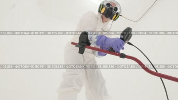 Man in white chemical protection suit holds metal detector. Стоковое видео, видеограф Aleksey Kidisyuk / Фотобанк Лори