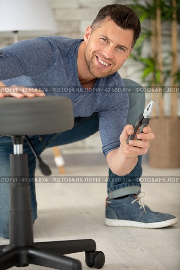 man is assembling an office chair. Стоковое фото, агентство Ingram Publishing / Фотобанк Лори