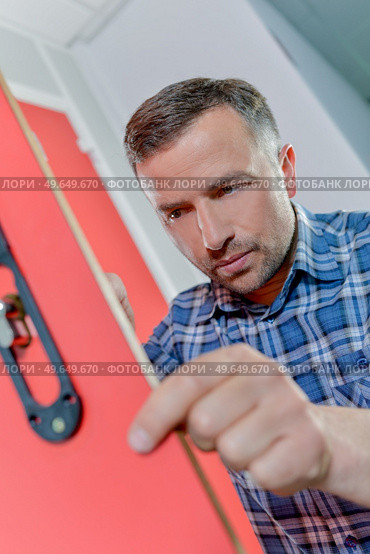 man is fixing a broken lock. Стоковое фото, агентство Ingram Publishing / Фотобанк Лори