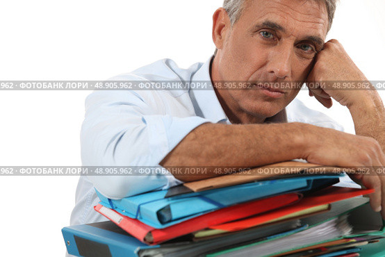 Man leaning on stack of work. Стоковое фото, агентство Ingram Publishing / Фотобанк Лори