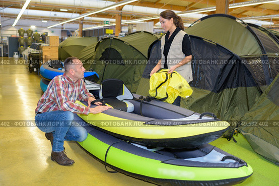 Man looking at inflatable dingys in a shop. Стоковое фото, агентство Ingram Publishing / Фотобанк Лори