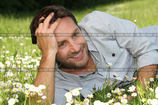 Man lying on grass. Стоковое фото, агентство Ingram Publishing / Фотобанк Лори