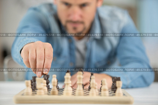 man making a move in a game of chesse. Стоковое фото, агентство Ingram Publishing / Фотобанк Лори