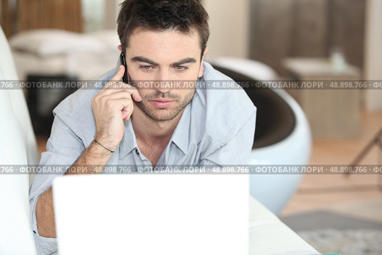 Man on the phone at the computer. Стоковое фото, агентство Ingram Publishing / Фотобанк Лори