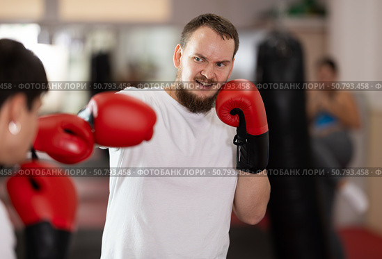 Man punches, tries to defeat guy opponent during training fight in ring. Стоковое фото, фотограф Яков Филимонов / Фотобанк Лори
