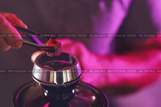Man putting coal cubes on tobacco bowl, closeup. Стоковое фото, фотограф Pixel_shot / Фотобанк Лори