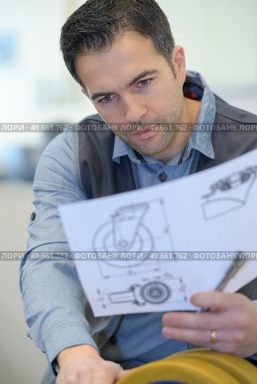 man reading instruction for large wheel. Стоковое фото, агентство Ingram Publishing / Фотобанк Лори
