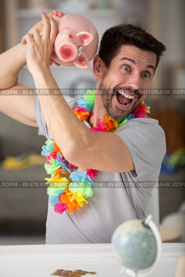 man save money on piggy bank screaming proud and celebrating. Стоковое фото, агентство Ingram Publishing / Фотобанк Лори
