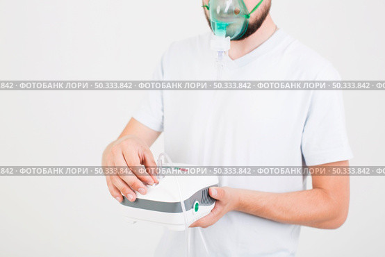 man setting medical nebulizer. Стоковое фото, агентство Ingram Publishing / Фотобанк Лори