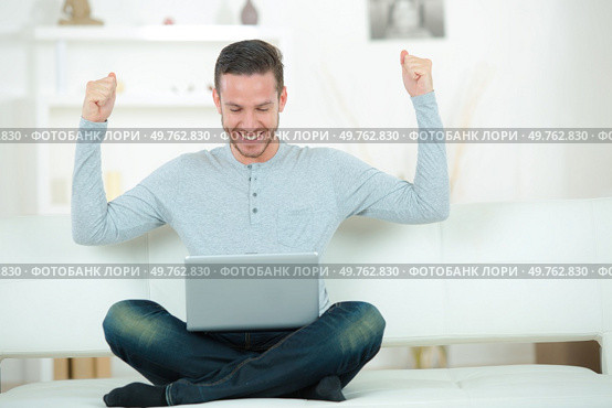 man sitting on sofa with arms up posture. Стоковое фото, агентство Ingram Publishing / Фотобанк Лори