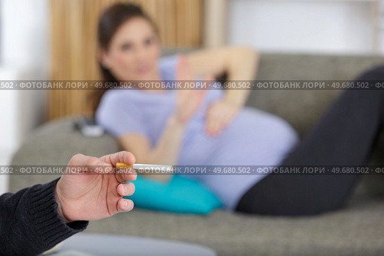man smoking near upset pregnant woman at home. Стоковое фото, агентство Ingram Publishing / Фотобанк Лори