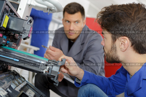 man training to fix a printer machine. Стоковое фото, агентство Ingram Publishing / Фотобанк Лори