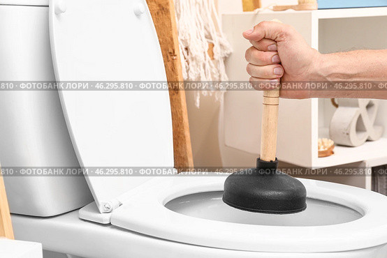 Man using plunger to unclog a toilet bowl. Стоковое фото, фотограф Pixel_shot / Фотобанк Лори