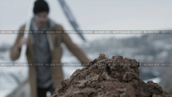 Man with the flag on top of the mountain inserts a flag in the ground, bottom view close up. Стоковое фото, фотограф David Kashakhi / Фотобанк Лори