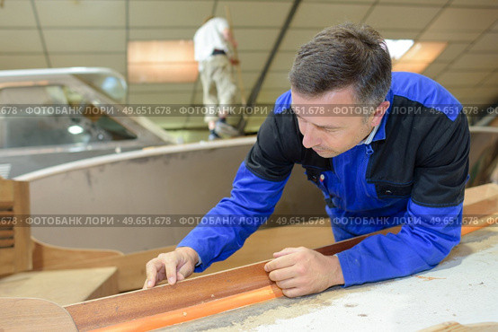 Man working with formica edging strip. Стоковое фото, агентство Ingram Publishing / Фотобанк Лори
