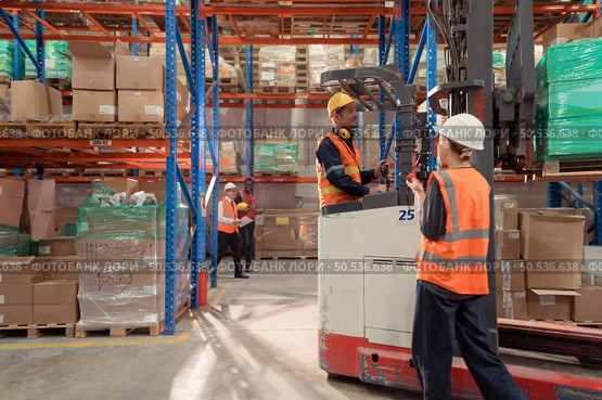 Managers, foremen and warehouse workers Consult together about getting the goods out of the warehouse to finish sending the small merchants tonight. Стоковое фото, агентство Ingram Publishing / Фотобанк Лори