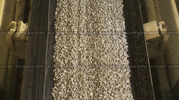 Many small crushed stones on the production line at the construction materials production factory, heavy industry concept. Стоковое фото, фотограф David Kashakhi / Фотобанк Лори