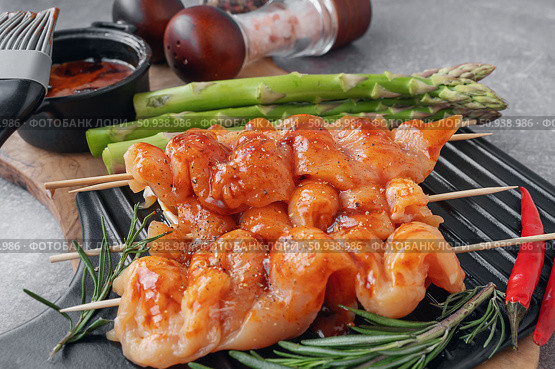 Marinated chicken kebab. Raw chicken breast kebab. Raw sliced chicken breast on wooden sticks with asparagus. Стоковое фото, фотограф Оксана Медведева / Фотобанк Лори
