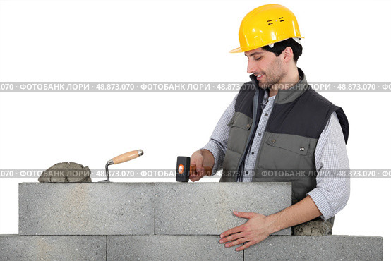 Mason mounting a brick wall. Стоковое фото, агентство Ingram Publishing / Фотобанк Лори