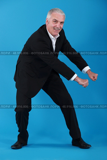 Mature businessman pretending to pull. Стоковое фото, агентство Ingram Publishing / Фотобанк Лори