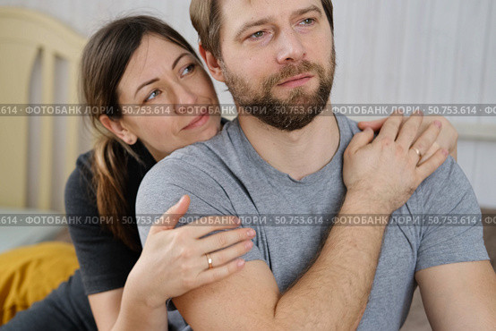 Mature couple hugging hugging each other kissing at home bedroom. Intimate Moment. Tender embrace shared between a loving middle age man and woman, husband and wife. Deep love. Low key, cinematic. Стоковое фото, фотограф Марина Демидюк / Фотобанк Лори