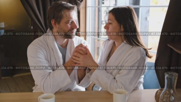 Mature couple in a white bathrobes hugging each other kissing at home room. Intimate Moment. Tender embrace shared between a loving middle age man and woman, husband and wife. Deep love. Vacation. Стоковое видео, видеограф Марина Демидюк / Фотобанк Лори