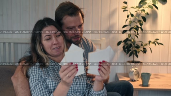 Mature Couple, Wife with Husband looks with interest at a vintage photography. Man and Woman looking at family photos. Genealogy, the memory of ancestors, family ties, memories of childhood. History. Стоковое видео, видеограф Марина Демидюк / Фотобанк Лори