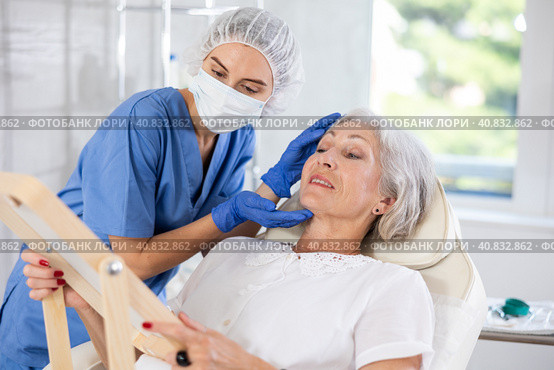 Mature patient with mirror, doctor with gloves. Стоковое фото, фотограф Яков Филимонов / Фотобанк Лори