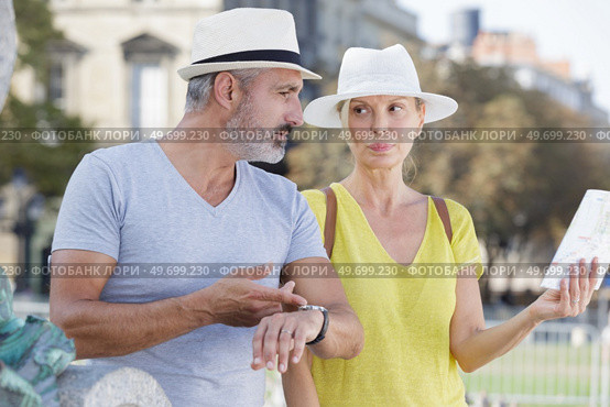 mature woman holding map man stressing the time restrictions. Стоковое фото, агентство Ingram Publishing / Фотобанк Лори