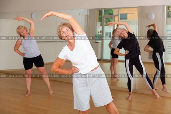 Mature women warming-up before their group fitness training. Стоковое фото, фотограф Яков Филимонов / Фотобанк Лори