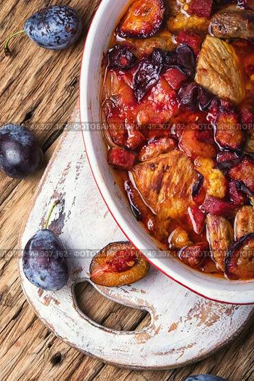 meat in plum sauce. meat stew in a sauce of autumn plums on a retro background. Стоковое фото, агентство Ingram Publishing / Фотобанк Лори