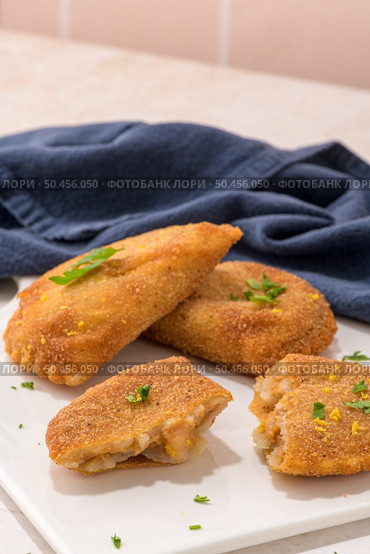 Meat patties and parsley leaves on white ceramic dishes in a kitchen counter top. Стоковое фото, агентство Ingram Publishing / Фотобанк Лори