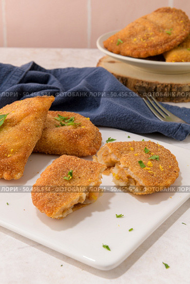 Meat patties and parsley leaves on white ceramic dishes in a kitchen counter top. Стоковое фото, агентство Ingram Publishing / Фотобанк Лори