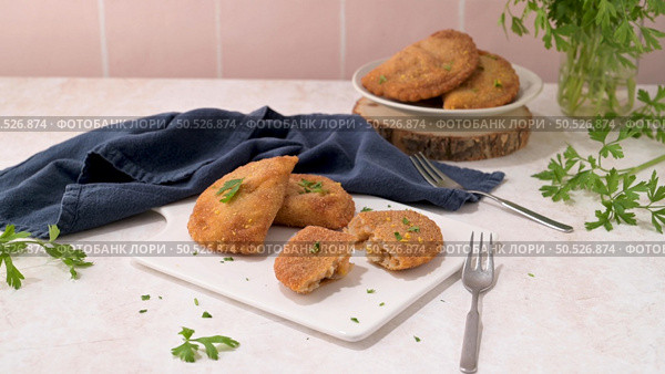 Meat patties and parsley leaves on white ceramic dishes in a kitchen counter top. Стоковое фото, агентство Ingram Publishing / Фотобанк Лори