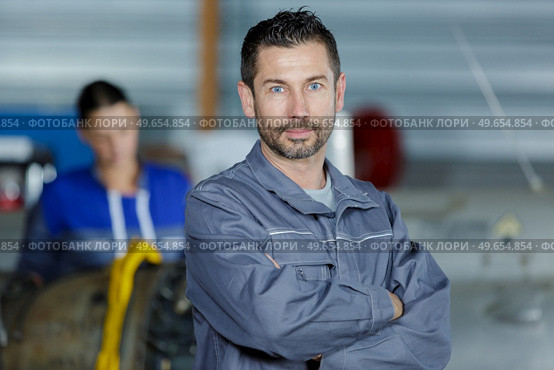 mechanic looking to camera beside a car. Стоковое фото, агентство Ingram Publishing / Фотобанк Лори