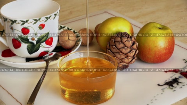 Мед наливают в баночку перед чаепитием. Замедленная съемка. Honey is poured into a jar before drinking tea. Slow motion. Стоковое видео, видеограф Горшков Александр / Фотобанк Лори