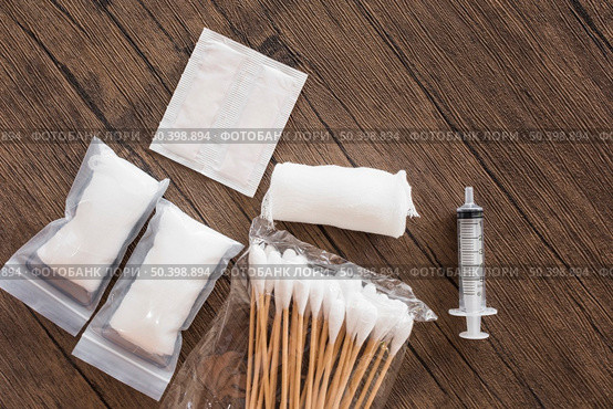 medical cotton gauze bandage syringe pack cotton swab wooden table. Стоковое фото, агентство Ingram Publishing / Фотобанк Лори