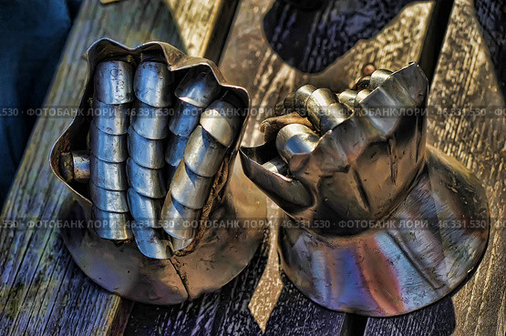 Medieval gauntlets, also known as gauntlets. These metal gloves are part of a knight's armor and served to protect the hands in combat. They consist of movable segments connected by rivets, which allows the fingers to be flexible when holding a weapon. Traces of use are visible, which gives them an authentic look.Such gauntlets were used in Europe in the 14th-15th centuries and were an important part of the armor, protecting the hands from blows from swords, axes and other types of bladed weapons. Стоковое фото, фотограф Анна Кривицкая / Фотобанк Лори