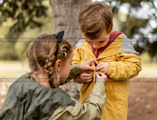medium shot girl helping brother. Стоковое фото, агентство Ingram Publishing / Фотобанк Лори