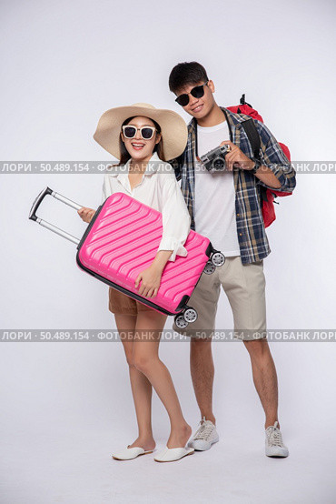 Men and women dressed up wearing glasses to travel with suitcases. Стоковое фото, агентство Ingram Publishing / Фотобанк Лори