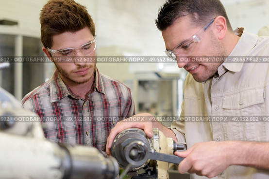 men mending a machine with goggles on. Стоковое фото, агентство Ingram Publishing / Фотобанк Лори