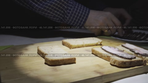 Men's hands spread slices of smoked bacon on grain bread. Стоковое видео, видеограф Ярославский Максим / Фотобанк Лори