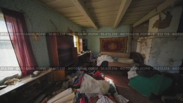 Messy living room in abandoned slavic village house with clothes scattered on floor. Стоковое видео, видеограф Mikhail Davidovich / Фотобанк Лори