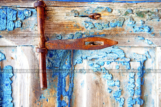 metal nail dirty     stripped paint in the brown   red wood door and rusty  knocker. Стоковое фото, агентство Ingram Publishing / Фотобанк Лори
