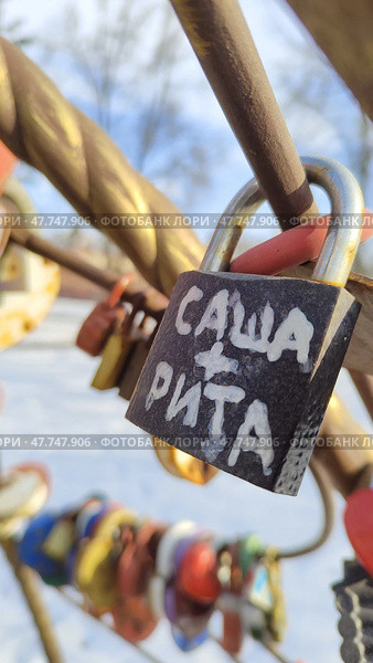 Металлический навесной замок с надписью: Саша + Рита. Традиция вешать замки в день свадьбы и выбрасывать ключи. Символ любви и верности. Стоковое фото, фотограф Ирина / Фотобанк Лори