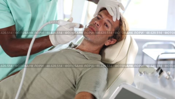 Middle-aged man undergoing facial treatment using ion bubble attachment for gentle exfoliation, deep hydration and skin revitalization at cosmetic medicine clinic. Male grooming concept. Стоковое видео, видеограф Яков Филимонов / Фотобанк Лори