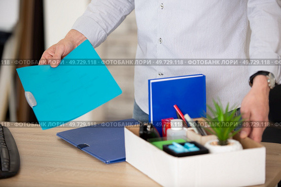 midsection view of a businessman tiddy belongings in cardboard box. Стоковое фото, агентство Ingram Publishing / Фотобанк Лори